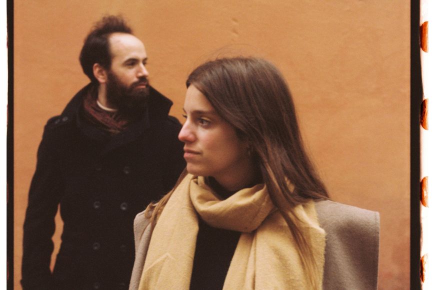 Noi i noia mirant-se amb fons taronja